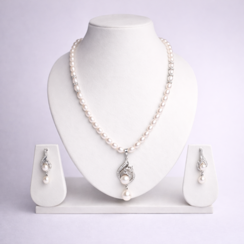 Silver-tone freshwater pearl necklace set with ornate pearl drop pendant and matching dangle earrings on white bust display
